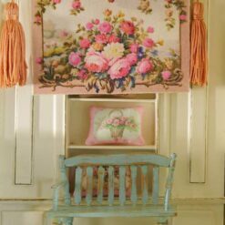 Miniature Aubusson tapestry showcasing roses cascading from a golden urn against a pastel backdrop.