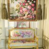 Ivory vase with colorful roses framed by a rich background, a miniature Aubusson tapestry.