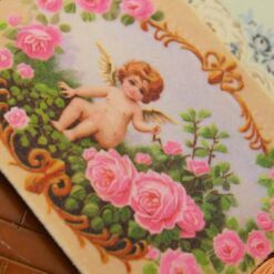 Cherub surrounded by pink roses and ornate golden details, a miniature Aubusson tapestry.