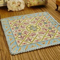 Miniature classic Aubusson rug with floral design and intricate border.