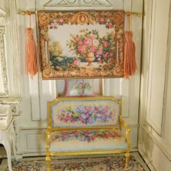 Miniature Aubusson tapestry featuring a golden urn with pastel roses framed by intricate scrollwork.