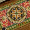 A unique Aubusson miniature rug featuring a floral medallion in rich, warm tones, ideal for vintage dollhouses.