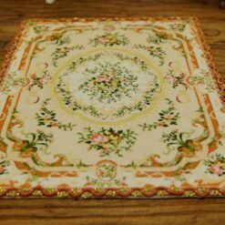 Miniature Victorian rug with floral design in muted tones.