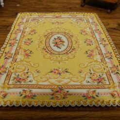 Miniature Aubusson rug with intricate floral design in gold.