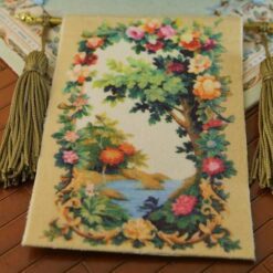 Lush tree with vibrant flowers and a river in a whimsical forest scene, a miniature Aubusson tapestry.
