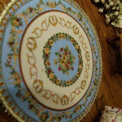 Miniature Victorian floral rug with delicate flowers and ornate borders.