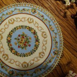Miniature Victorian floral rug with delicate flowers and ornate borders.