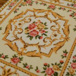 Miniature red and yellow Victorian rug with rose and scroll design.