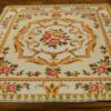 Miniature red and yellow Victorian rug with rose and scroll design.