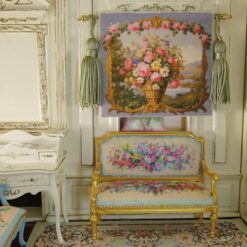 Wicker basket filled with roses and daisies against a scenic backdrop in a miniature Aubusson tapestry.
