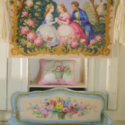 Miniature Aubusson tapestry showing a garden scene with two women and a man surrounded by roses and golden flourishes.