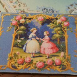 Two Victorian ladies in a rose garden framed by gold and blue accents, a miniature Aubusson tapestry.