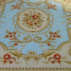 Miniature classic Victorian rug with floral pattern in blue and red.