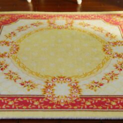 Miniature Aubusson square rug with floral border and yellow center.