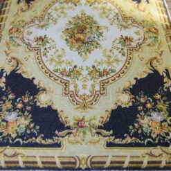 Black Aubusson rug with sunburst design in the center surrounded by floral details.