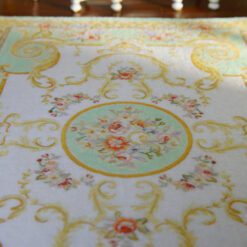Soft green Victorian rug with rose motifs and gold accents
