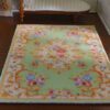 Victorian Rococo miniature rug with light green background and floral scrolls