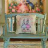 Miniature pillow pattern with rabbits in pastel dresses and pink rose frame
