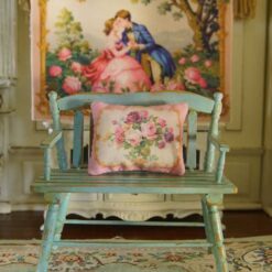 Miniature pillow with pink, purple, and yellow roses framed by a golden border