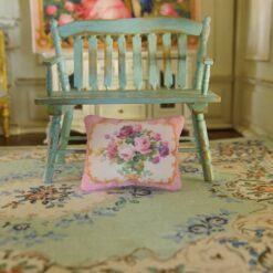 Miniature pillow with pink, purple, and yellow roses framed by a golden border
