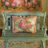 Miniature pillow with red and pink roses framed by golden scrolls
