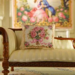 Miniature pillow with a pink rose bouquet tied with a pink ribbon and golden frame