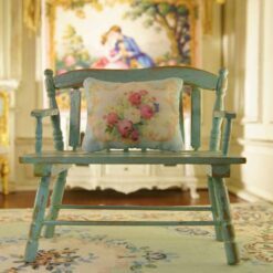 Miniature pillow with vibrant floral design framed by golden ornate details