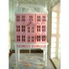 Pink townhouse dollhouse on white table with drawers