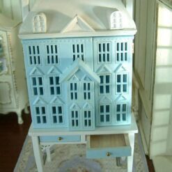 Blue townhouse-style miniature dollhouse with white table