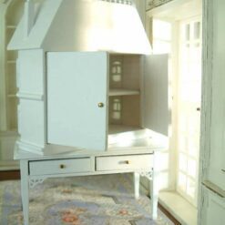 Victorian-style miniature dollhouse cabinet in white on a two-drawer table