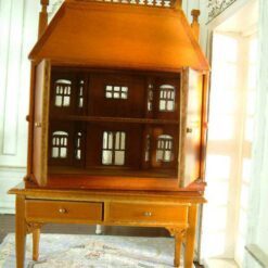 Victorian-style dollhouse cabinet in walnut finish with two-drawer table