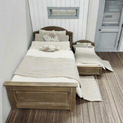 A vintage dollhouse bed with a cozy and detailed design.