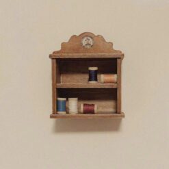 A miniature spool storage cabinet with vintage design.