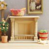 Miniature dollhouse fireplace with detailed wooden columns and natural finish