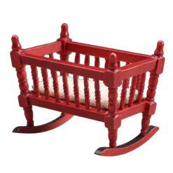 Miniature wooden rocking cradle for dollhouse nursery.