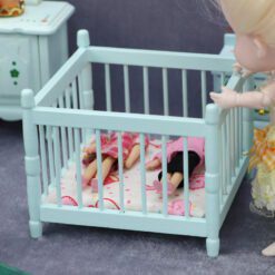 Miniature blue baby crib for dollhouse nursery.