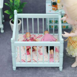 Miniature blue baby crib for dollhouse nursery.