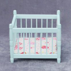 Miniature blue baby crib for dollhouse nursery.