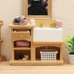 Miniature wooden bathroom sink cabinet with white sink and gold faucets for dollhouses.
