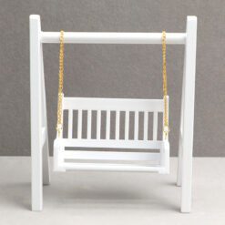 Miniature swing with a white frame and golden chains