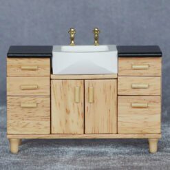 Miniature sink cabinet with black countertop and gold faucets for dollhouse bathrooms.