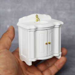 Miniature white vanity sink for dollhouse bathroom.