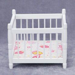 Miniature white baby crib for dollhouse nursery.