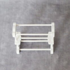 Miniature white towel rack made from wood and bamboo for dollhouse bathrooms.