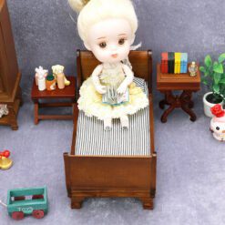 Miniature wooden bed with striped bedding for dollhouse